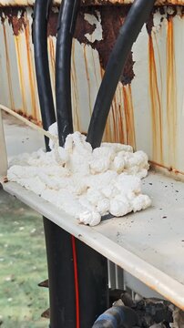 Utility worker injecting expanding foam to seal hole during underground cable repair.