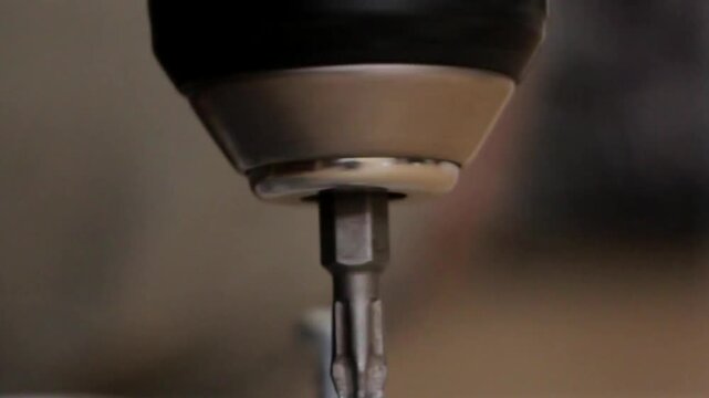 A drilling machine screwing down a screw