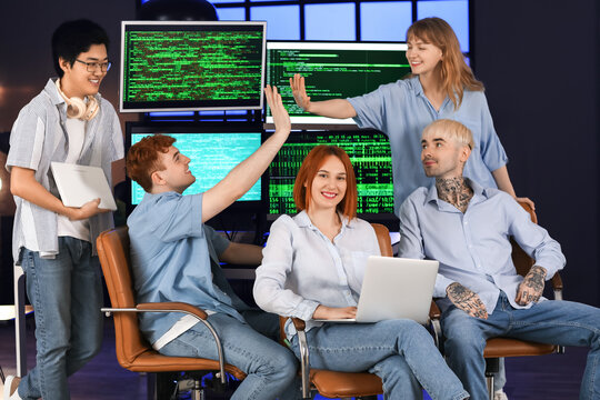 Team of young programmers working in office at night