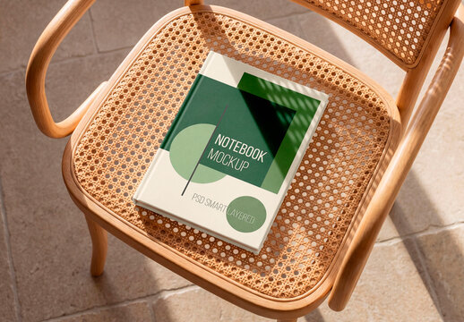 Blank hardcover book mockup on rattan chair with sunlight shadows