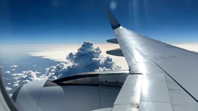 Scenic view of a plane wing with a clear blue sky and puffy clouds during flight travel