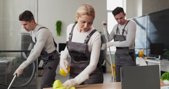 Cleaners team crew janitors doing office cleaning. Coordinated staff sanitize a workspace as one wiping a desk another vacuuming, and a third mopping. Concept illustrates cleaning service teamwork.