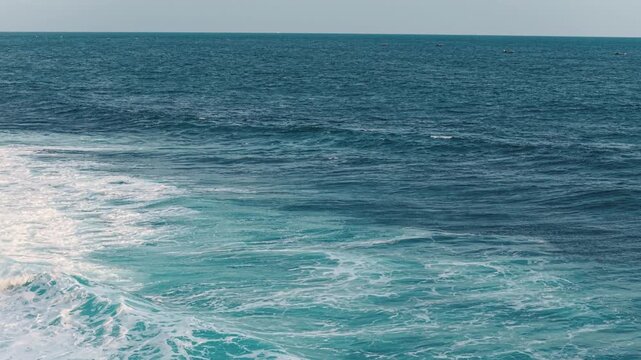 Aerial view of turquoise waves breaking with white foam at Mesra Beach in Kecamatan Tanjungsari, Daerah Istimewa Yogya, Indonesia.