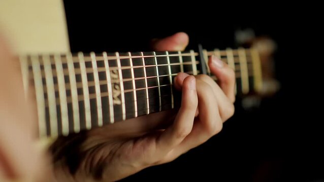 close up man playing guitar