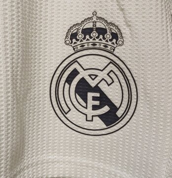 Vista de cerca del logotipo del club de f&uacute;tbol Real Madrid, en camiseta de deportes, en tienda Primark en Madrid, Espa&ntilde;a, 18 de marzo de 2026
