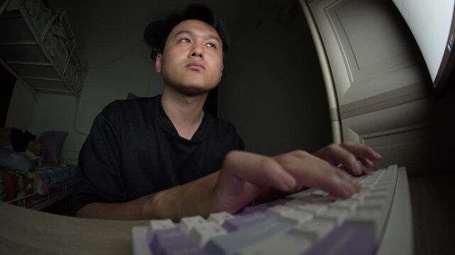 Fisheye POV Close Up of Asian man Hands Type on Keyboard with Blue Screen Light in Dark Room