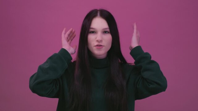 Teen girl making a mind blown gesture near her head, expressing amazement or disbelief. Beautiful female, generation Z or alpha twists and shakes her hands at her head, a crazy gesture.