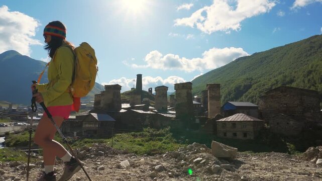 Ushguli, Georgia - 16th july, 2025: Traveler hiking with backpack and poles in Ushguli, Svaneti mountains, wellness trekking and adventure lifestyle in Caucasus