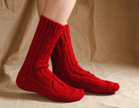 Red cable-knit socks on beige backdrop