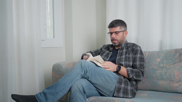 Man Reading Book on Sofa at Home Relaxing Quiet Lifestyle Scene