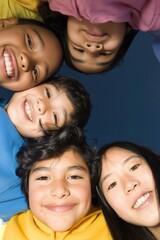 Obraz premium Group of children smiling and leaning in against blue background