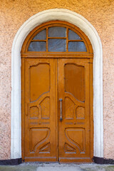 Fototapeta premium Antique classic brown entrance door with glass inserts in an old house