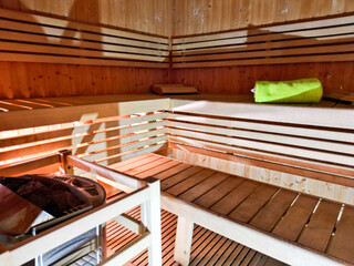Drewniane wnętrze sauny w obiekcie hotelowym lub strefie wellness. Ciepłe światło, naturalne drewno i spokojny klimat podkreślają relaks, odpoczynek oraz komfort korzystania ze strefy spa. © Freshfanpage