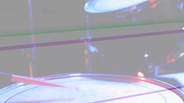 Stage lights sweeping, camera tilting upward right, revealing drum head and tom showing kit layout