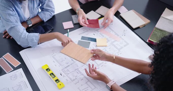 Diverse female designers placing wood sample, arranging swatches on plan in office, checking scale