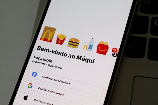 Salvador, Brazil - April 24, 2026: Smartphone with the McDonald's (M&eacute;qui) app on screen. Welcome to McDonalds (Bem-vindo ao M&eacute;qui). Brazilian McDonalds app concept. 