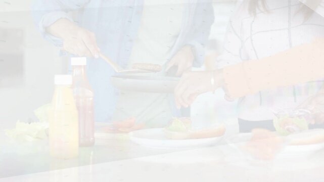 Triangular wipe revealing countertop, two cooks using pan and spatula to plate food
