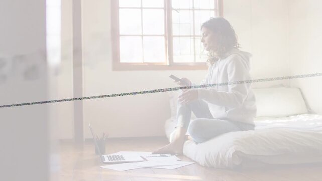 Woman sitting on mattress tapping phone then checking laptop notes static line crossing education