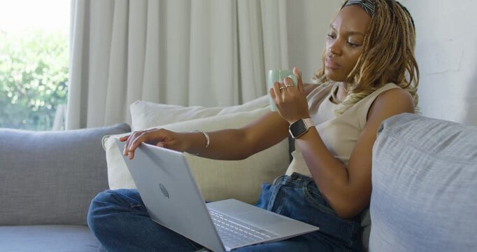 Woman ending work, typing, sipping mug, closing laptop and gazing out window, copy space