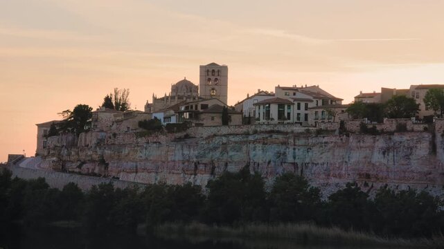 Medieval city of Zamora with its cathedral perched on a cliff during a beautiful sunset in Spain, showing a historical landscape