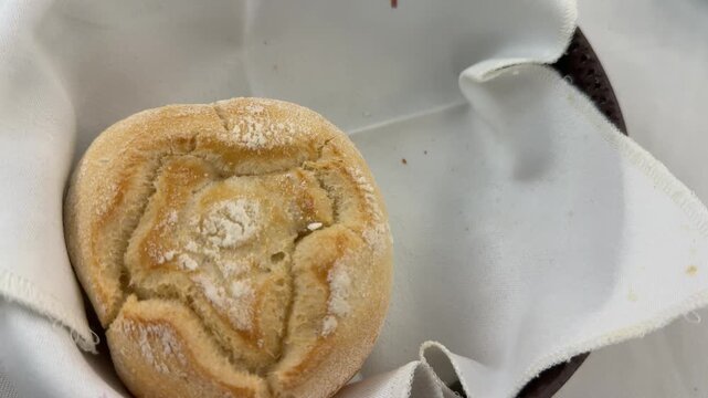 Taking bread roll from basket with two rolls, close up restaurant serving, clow mode