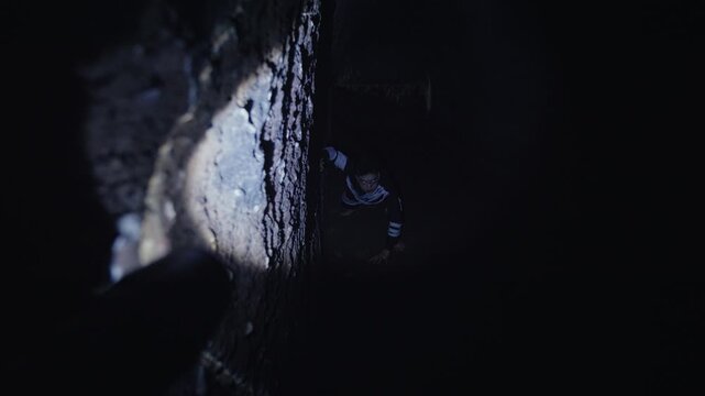 Peering from the Shadows at a Man in a Dark Tunnel