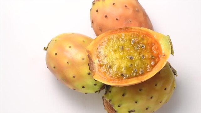 Prickly pear cactus, Opuntia edible fruit macro shot. Fresh tasty sweet whole exotic fruits. Opuntia ficus indica rotating on white background 