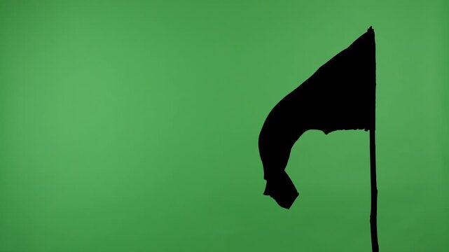 Black flag on a pole against a green background with alpha channel. Concept of symbol, protest, warning, anonymity, and chroma key element for video editing and design.