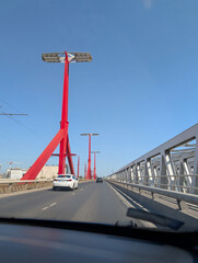 Fototapeta premium Modern bridge roadway with red light poles and cars in perspective, Budapest