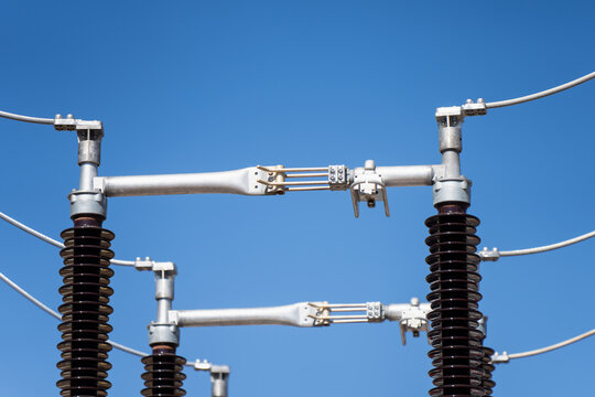 Electric utility substation hardware featuring porcelain insulators and metal conductor connections essential for renewable energy integration and power systems