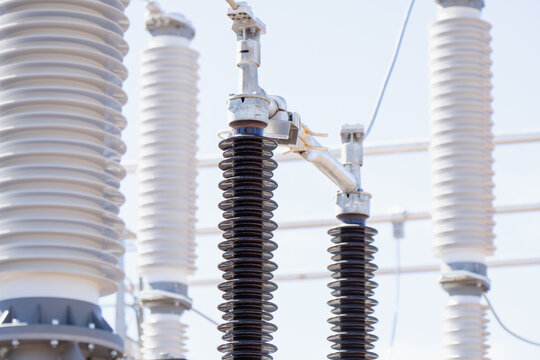 High voltage porcelain station post insulators and circuit breaker bushings at a substation yard managing energy shortages and rising electricity prices in the power sector