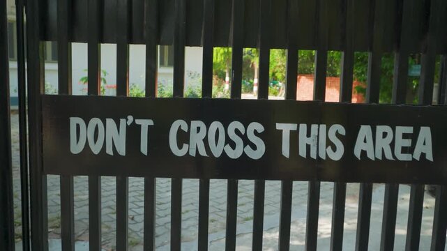 Don't cross this area warning sign on black gate