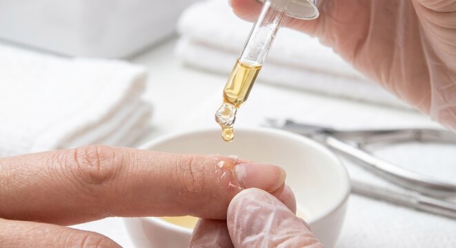 Applying nourishing oil to dry cuticles during manicure