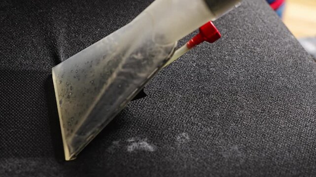 Wet vacuuming a chair to remove dirt and stains