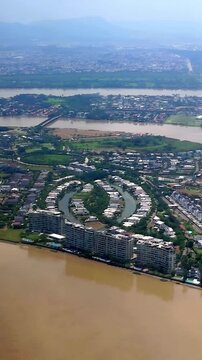 From the airplane window, the city of Guayaquil and the Guayas River are visible just minutes before landing. The scene captures the urban landscape and natural beauty of Ecuador as the aircraft appro