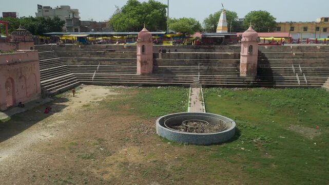 Bakshi ka Taalab, Empty stepped ghat courtyard with temple towers and fountain
