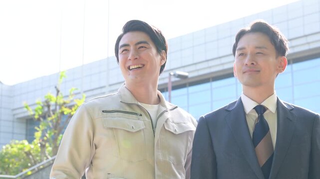 [スローモーション]作業着とスーツの施工管理士と若手技術者が未来を見つめるインフラやゼネコン、建設業の人材育成イメージ　見上げる動画