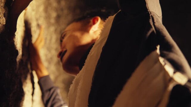 Close-Up of a Frightened Man Hiding in a Dark Cave