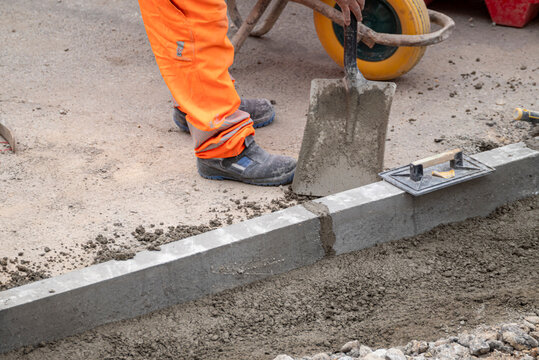 Construction worker pouring cement for a curb The Concept of manual labor