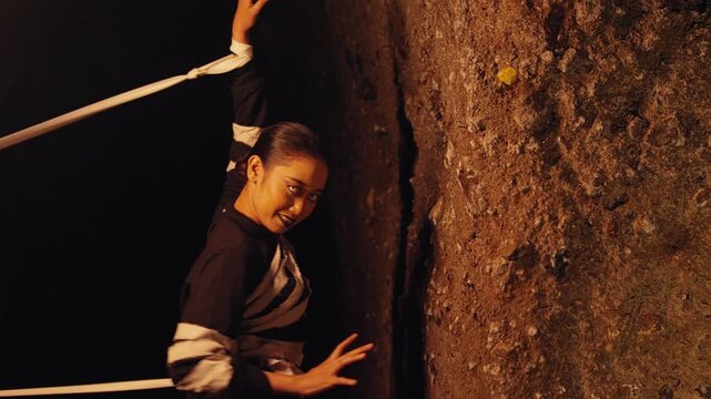 Manic Woman with Bound Hands Against a Cave Wall