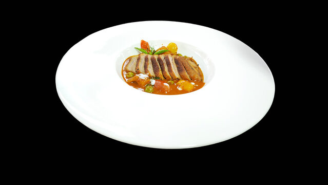 Authentic Thai roasted duck red curry (Gaeng Phed Ped Yang) in a modern white plate on black  background.