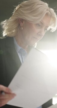 Documents, signature and businesswoman in office with contract for finance investment deal. Paperwork, writing and mature female financial manager with approval for company budget report by flare.