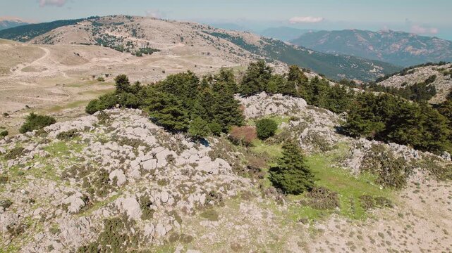 Rocky highland with scattered trees overlooking mountain range in Kefalonia Greece