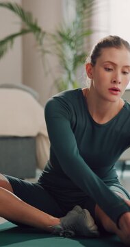 Stretching, legs and woman on floor in home for fitness routine, wellness and pilates. House, morning and person on exercise mat for workout, warm up and active hobby for mobility, muscles and health