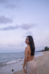 Obraz premium Portrait gorgeous charming relaxed Asian woman lady girl female sitting performing meditation beach sand ocean sea. Happy woman walking on beach