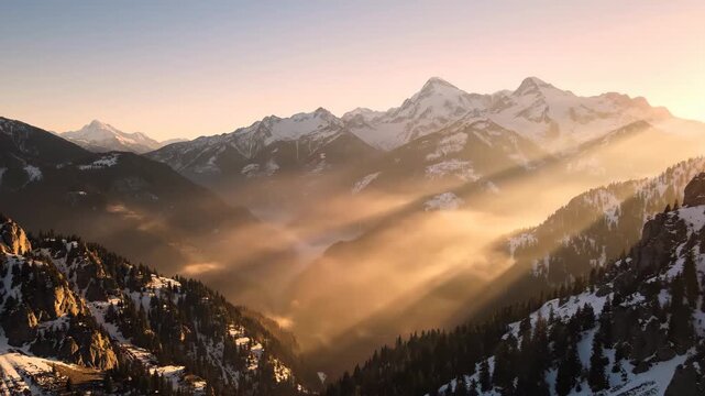 Aerial drone footage of misty sunrise over snow-capped mountain range in 4k cinematic motion