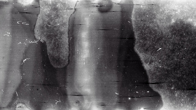 Blank grained film strip texture background with heavy grain, dust and light leak. Old expired soviet moldy photographic film scan. Black and white.