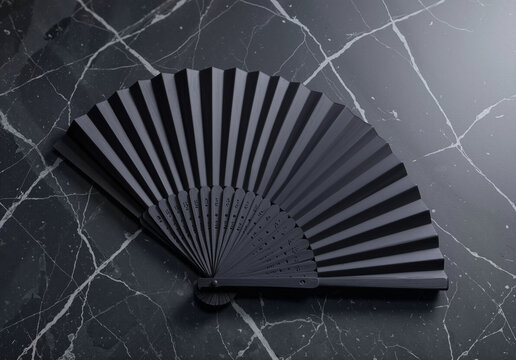 Blank black folding hand fan mockup lying on marble, ai generated. Empty open vintage paperfan for summer accessory, top view. Clear wind air or interior pleated handfan for cooling or decor template.