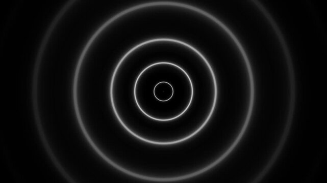 Multiple concentric white rings radiating from a central point against a dark black background creating a clean and minimalist abstract pattern
