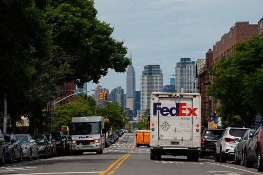 NYC street with two FedEx delivery trucks side by side, package delivery background image, city environment 